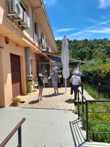 un grupo de personas caminando fuera de un edificio con un paraguas en Hotel l'Albera en La Jonquera
