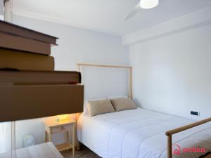 - une chambre avec un lit et une pile de livres dans l'établissement La Postal, à Benicàssim