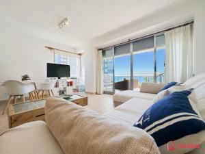 un salon avec un canapé et une vue sur l'océan dans l'établissement La Postal, à Benicàssim