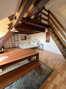 a room with a bed and a wooden staircase at CASA RUSTICA Bodensee Ferienwohnungen in Stetten