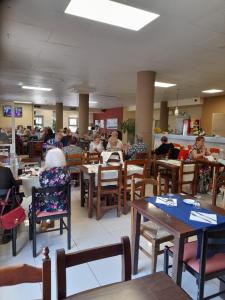 un grupo de personas sentadas en mesas en un restaurante en Hotel l'Albera en La Jonquera