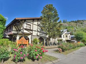 ein großes Haus mit Blumen davor in der Unterkunft Ayres del Filo by Visionnaire in San Martín de los Andes