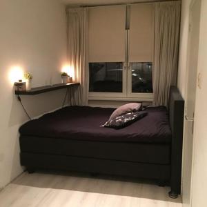 uma cama num quarto com uma janela e uma cama sidx sidx em Trendy apartment garden Amsterdam center em Amsterdã