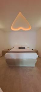 um quarto com uma cama com uma grande luz por cima em Pegasus Suites & Spa em Imerovigli
