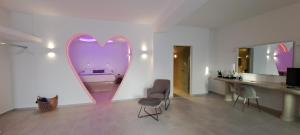 Habitación con espejo en forma de corazón, mesa y sillas. en Pegasus Suites & Spa, en Imerovigli