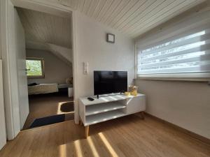 uma sala de estar com televisão numa cómoda branca em Apartment in Vaihingen an der Enz - Horrheim em Vaihingen an der Enz
