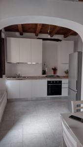 a kitchen with white cabinets and a black appliance at Casa di Anna in Baunei