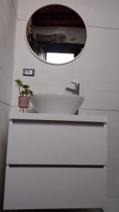 a bathroom with a white sink and a mirror at Casa di Anna in Baunei