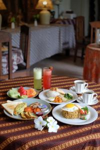 a table with plates of breakfast food on it at Rumah Mertua Heritage in Yogyakarta