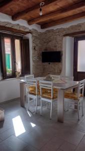 a dining room with a white table and chairs at Casa di Anna in Baunei