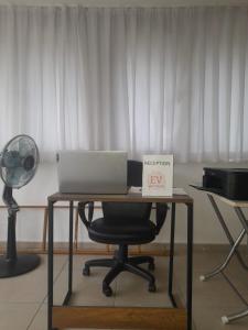 a desk with a laptop and a chair with a fan at EV Apartments in Belek