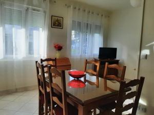 a dining room with a table and chairs and a television at Paris - Bords de Marne in Saint-Maur-des-Fossés