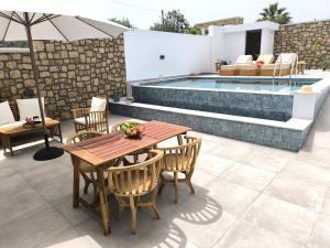 a patio with a table and chairs and a pool at Valantina's & Mannouel Lardos Luxury Villas in Lardos