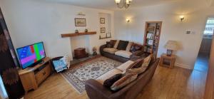a living room with a couch and a television at Two bedroom character cottage in Rhuddlan