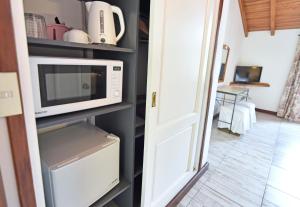 a kitchen with a microwave on a shelf at Plaza Mayor by Visionnaire in San Martín de los Andes