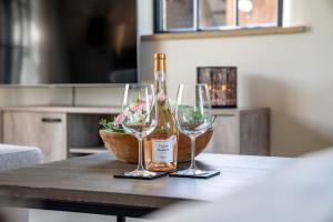 a bottle of wine and two wine glasses on a table at Hoeve den Akker - luxueuze vakantiewoningen met privétuinen en alpaca's nabij Brugge, Damme, Knokke, Sluis en Cadzand in Damme