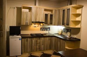 a kitchen with wooden cabinets and a white refrigerator at Hostel Q ,15 хв до жд вокзалу in Lviv