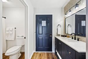 a bathroom with a toilet and a blue door at Fresh Coast Motel in Fish Creek