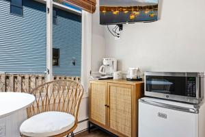 a small kitchen with a microwave and a table and chairs at Fresh Coast Motel in Fish Creek