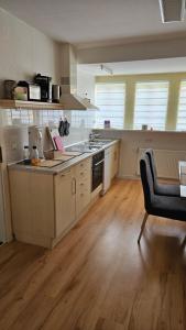 a large kitchen with wooden floors and a table and a chair at Ferienwohnung Lehmann in Wolfenbüttel