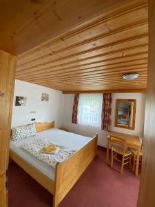 a bedroom with a bed and a wooden ceiling at Pension Leitenhof in Niederau