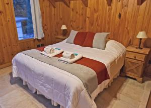 sypialnia z łóżkiem z ręcznikami w obiekcie Apart Hotel Orilla Mansa by Visionnaire w mieście San Martín de los Andes