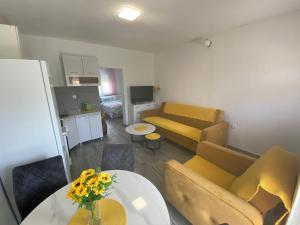 a living room with a couch and a table with flowers at OLGA APARTMENT in Kotor