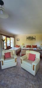 a hotel room with two beds and couches at Hotel Risco Plateado Room & Suite in Malargüe