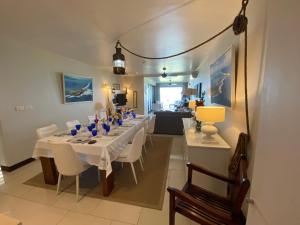 波茲迪尼的住宿－Sablexotique，用餐室配有长桌子和白色椅子