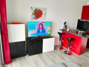 ein Wohnzimmer mit einem Flachbild-TV auf einem Stand in der Unterkunft Studio Les Jardins de la Mer in Bandol