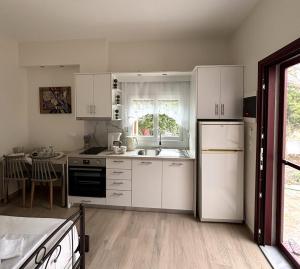 a kitchen with white cabinets and a sink at Dream apartments by Depi in Skala Eresou