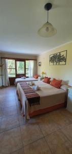 a bedroom with two beds and a large window at Hotel Risco Plateado Room & Suite in Malargüe