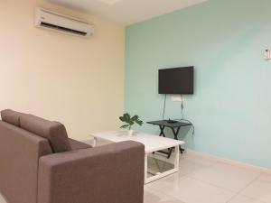 ルムットにあるMarina Island Seaview Homestayのソファ、テレビ、テーブルのあるリビングルーム