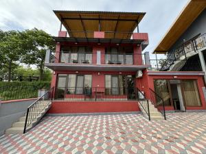 チャルトゥボにあるLake Houseの赤い建物(屋根付きバルコニー付)