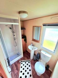 a small bathroom with a toilet and a sink at 8 Berth Static Caravan in Patrington +27 photos
