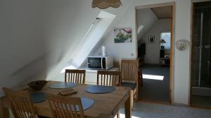 a dining room with a table and chairs and a staircase at Gård in Borre