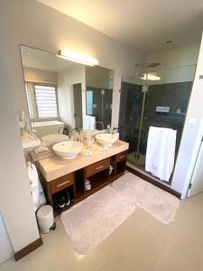a bathroom with two sinks and a large mirror at Sablexotique in Pointe d'Esny