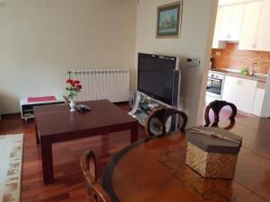 ein Wohnzimmer mit einem Tisch und einem TV in der Unterkunft Villa Ella in Opatija