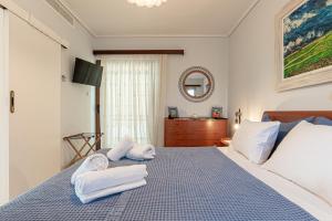 a bedroom with a bed with towels on it at Feliz Apt- Breathtaking Seaview and Sunset by ΜΡS in Anavyssos