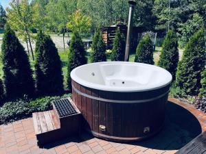 Brzozowa Aleja في رادافا: حوض استحمام كبير في حديقة بها أشجار