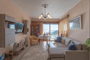 a living room with a couch and a table at Feliz Apt- Breathtaking Seaview and Sunset by ΜΡS in Anavyssos
