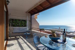 a balcony with a table and a view of the ocean at Feliz Apt- Breathtaking Seaview and Sunset by ΜΡS in Anavyssos