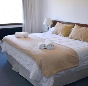 sypialnia z dużym łóżkiem z ręcznikami w obiekcie Hotel Caupolican by Visionnaire w mieście San Martín de los Andes