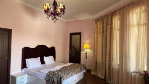 Schlafzimmer mit einem Bett und einem Kronleuchter in der Unterkunft Ivy Boutique Hotel in Yerevan