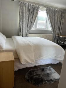 um quarto com uma cama branca e uma janela em Oxborne Rooms UK - 22 Seaton em Londres