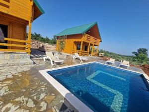 a house with a swimming pool next to a building at Bungalovi Spahic in Ulcinj