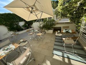 a patio with a table and chairs and an umbrella at B&B 125Metri sul mare in Sirolo