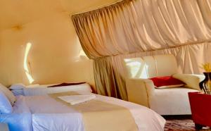 una habitación de hotel con 2 camas y una silla en Xperience golden rum camp en Wadi Rum