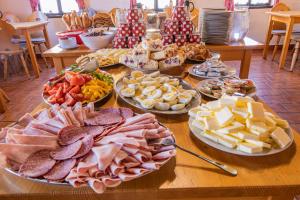 una mesa llena de diferentes tipos de queso y carne en Penzion Sněžná Volary, en Volary