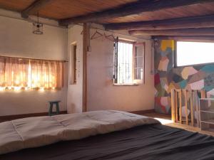 een slaapkamer met een groot bed en een kleurrijke muur bij CASA CIELO in Villa Berna